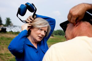Marjorie McCullagh, PhD, RN, FAAOHN demonstrates the proper use of hearing protection.
